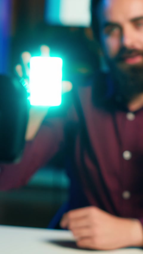 テックグルーが小型 LED ライトのテクノロジーレビューをビデオ撮影しています。フィードバックを提供し、クローズアップで撮影しています。フレンドリーなオンラインスターが、視聴者にフィルミング機器を見せながら、マイクで話しかけています。 ストック動画、ロイヤリティフリークリップ、HDビデオ動画. 動画素材 235692859
