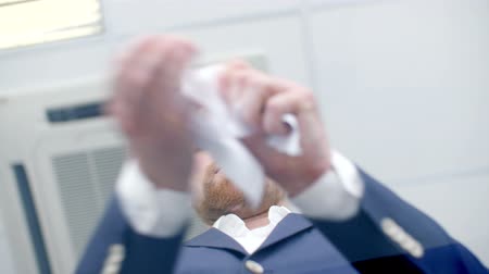 Angry businessman tearing a paper in pieces. shoot from below.