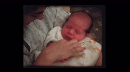 Mother holding newborn after feeding bottle 1959